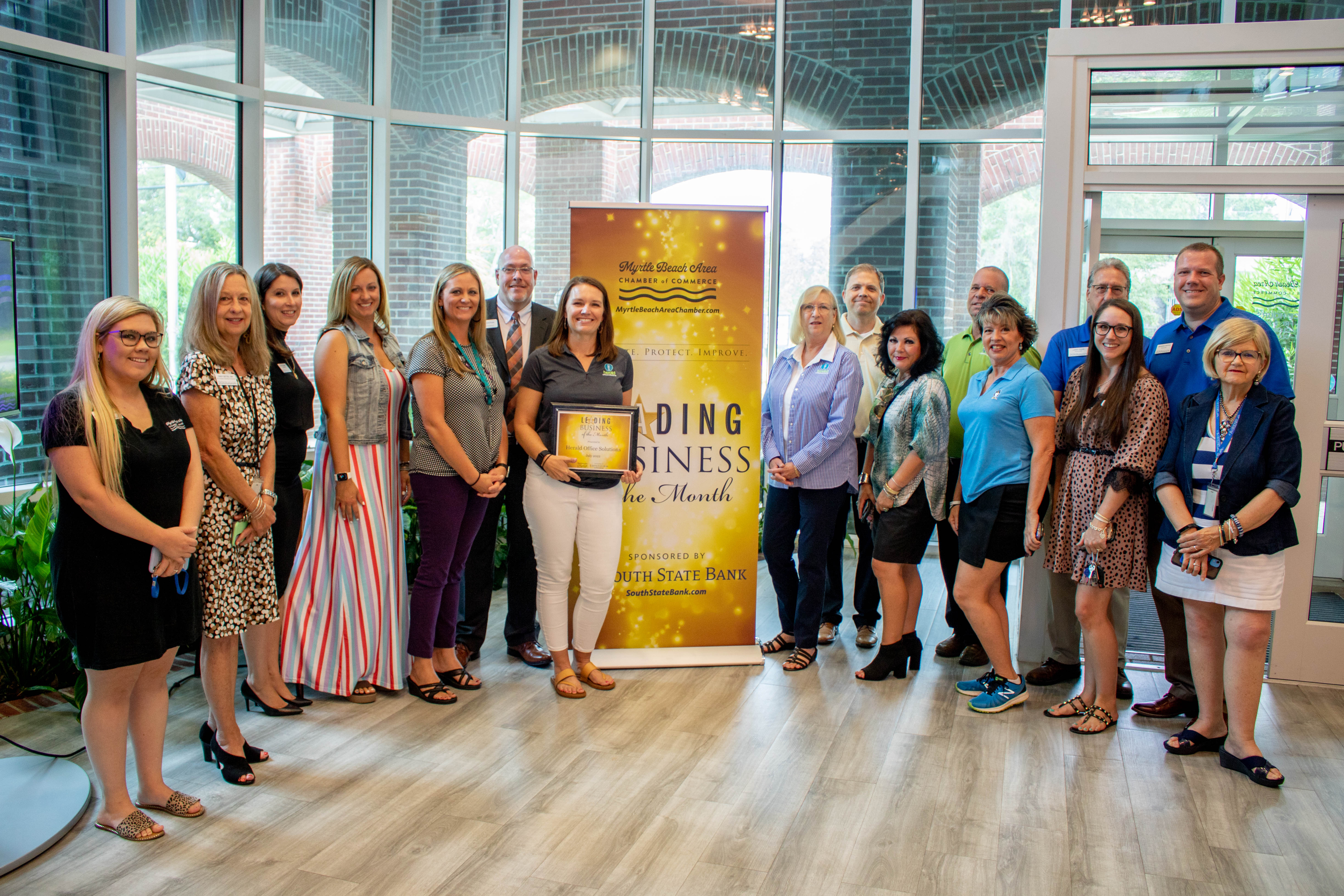 Herald Office Supplies Employees, Chamber Staff and ambassadors smile for photo