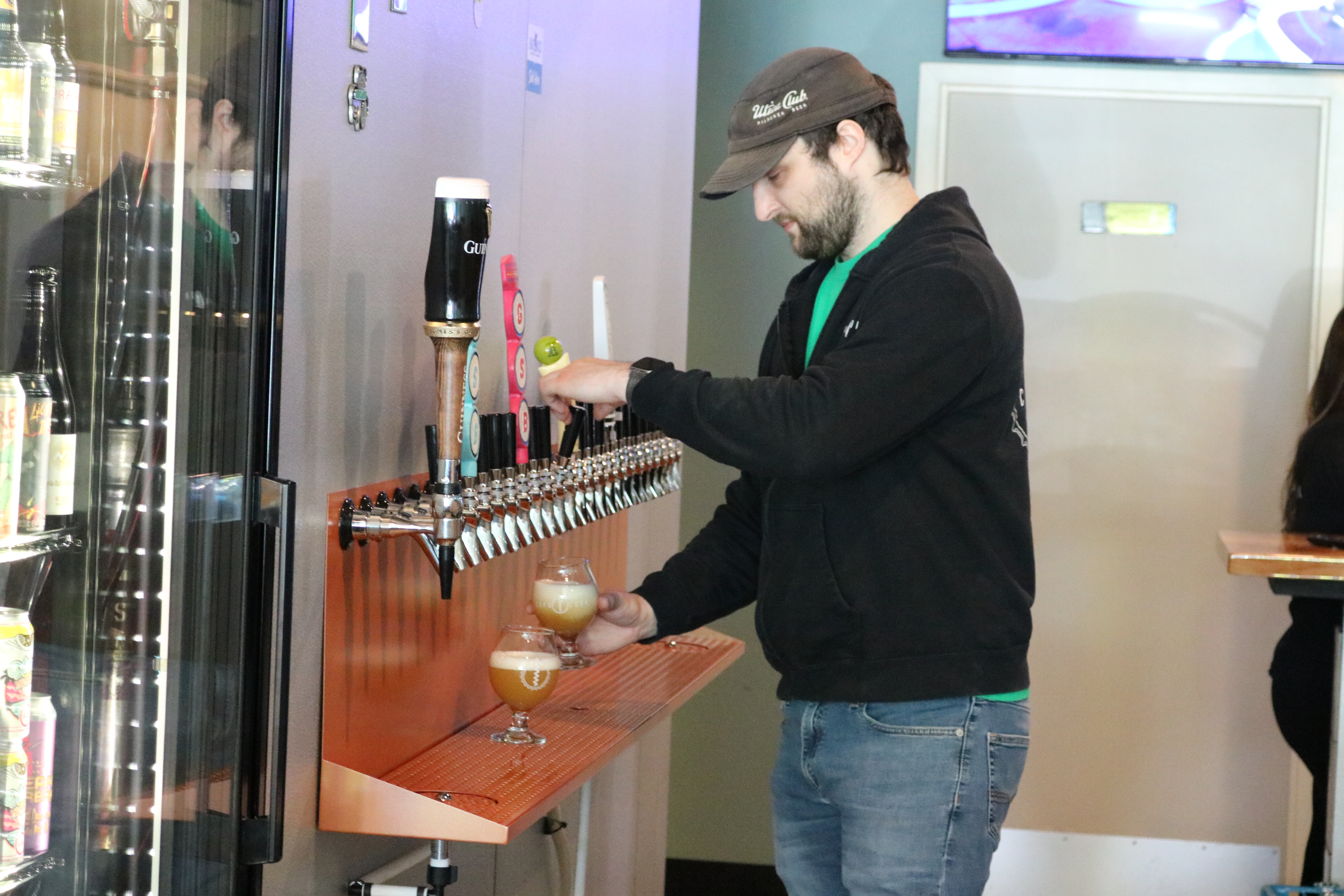 joey albanese pours a beer from a tap at cap'n cork