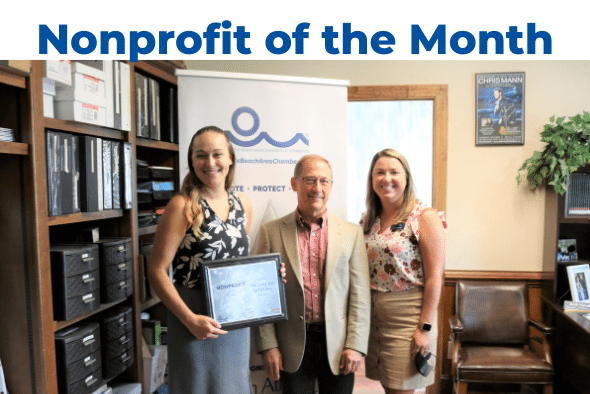 three people smiling at camera, one holding award plaque