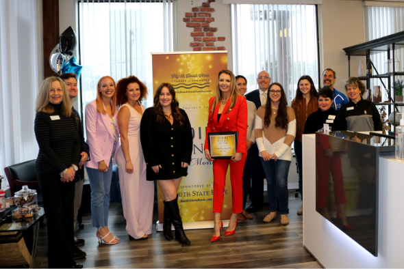 design the sign employees smile for picture in front of award banner