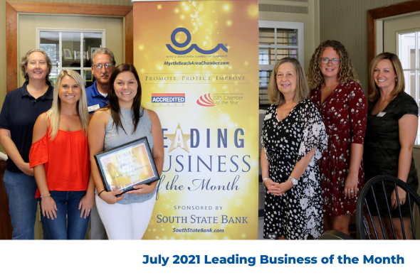 group of people in front of banner reading leading business of the month