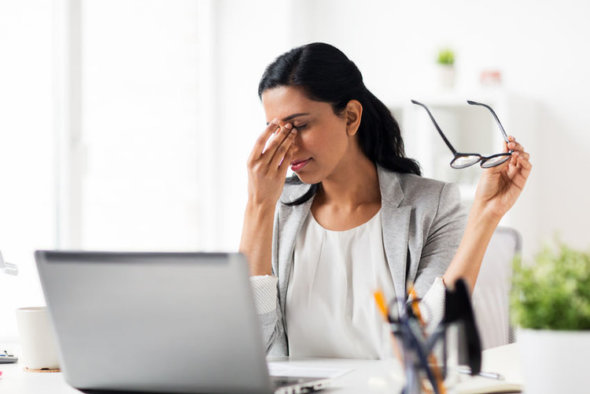 woman holding glasses and rubbing eyes