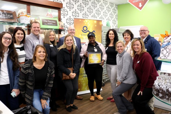 chamber staff and ambassadors smile for a picture with an employee from Kilwins