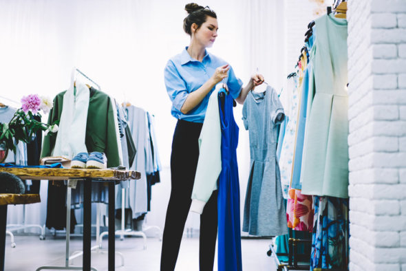 woman at clothing rack picking out items